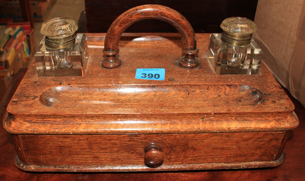 A Victorian oak inkstand with two glass wells and drawer. 14" wide