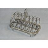 A William IV silver six division toast rack with ring handle, gadrooned base on cast scoll feet.