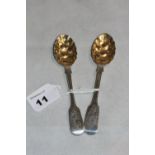 A pair of Victorian silver berry spoons, fiddle pattern, with parcel gilt bowls embossed with fruit.