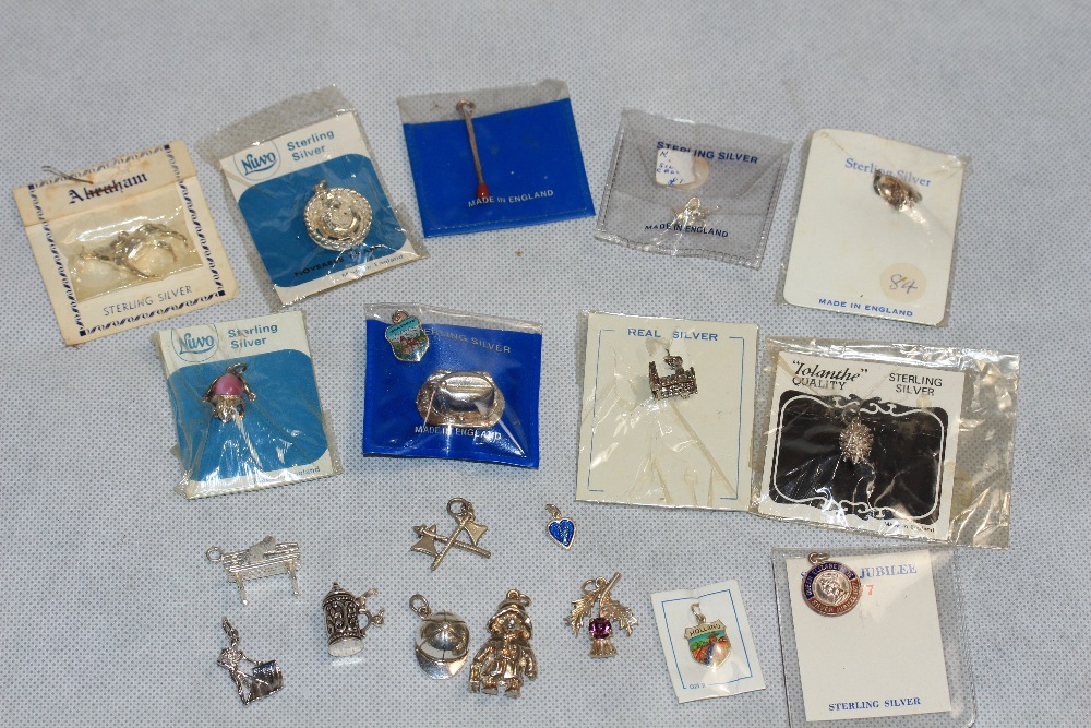 Twenty silver charms in a brass state Express cigarette box