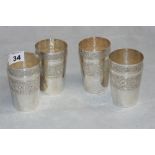 A set of four tapered silver cups, chased with a band of meandering foliage. 3 7/8" high. Brunei,