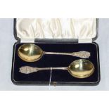 A pair of George V silver serving spoons with foliate chased terminals and parcel gilt bowls.