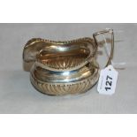 An Edward VII silver cream jug of half gadrooned helmet design. 5 ½" long over handle. Chester 1909.