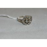 A white stone cluster ring. In white gold marked 750. 3.8g gross. Size N (one vacant setting)