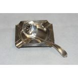 A silver engine turned ashtray Birmingham 1936 and a silver sifter spoon, Sheffield 1929. 1oz