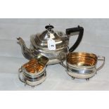 A George V silver three piece tea service of oblong form on ball feet, comprising teapot, (engraved)