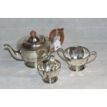 A George V silver three piece tea service of facetted round form, comprising teapot, sucrier and