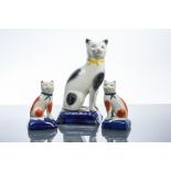 19TH CENTURY STAFFORDSHIRE FIGURE OF A SITTING CAT
resting on a blue cushion,