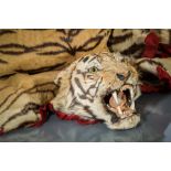 EARLY 20TH CENTURY TIGER SKIN AND MOUNTED HEAD
with red baize felt border, circa 1920,
