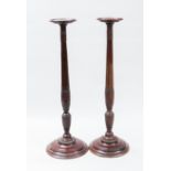 PAIR OF MAHOGANY BEDPOST TORCHERES
each on a stepped circular base,