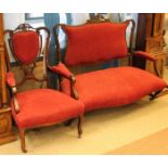 VICTORIAN MAHOGANY FRAMED SETTEE AND ELBOW CHAIR each with pierced back and upholstered in ruby red