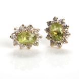 PAIR OF PERIDOT AND DIAMOND CLUSTER EARRINGS each set with a single oval emerald approximately 5.