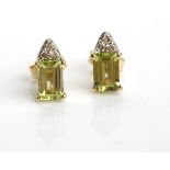 PAIR OF PERIDOT AND DIAMOND STUD EARRINGS each with an emerald cut peridot 6mm x 4mm set below