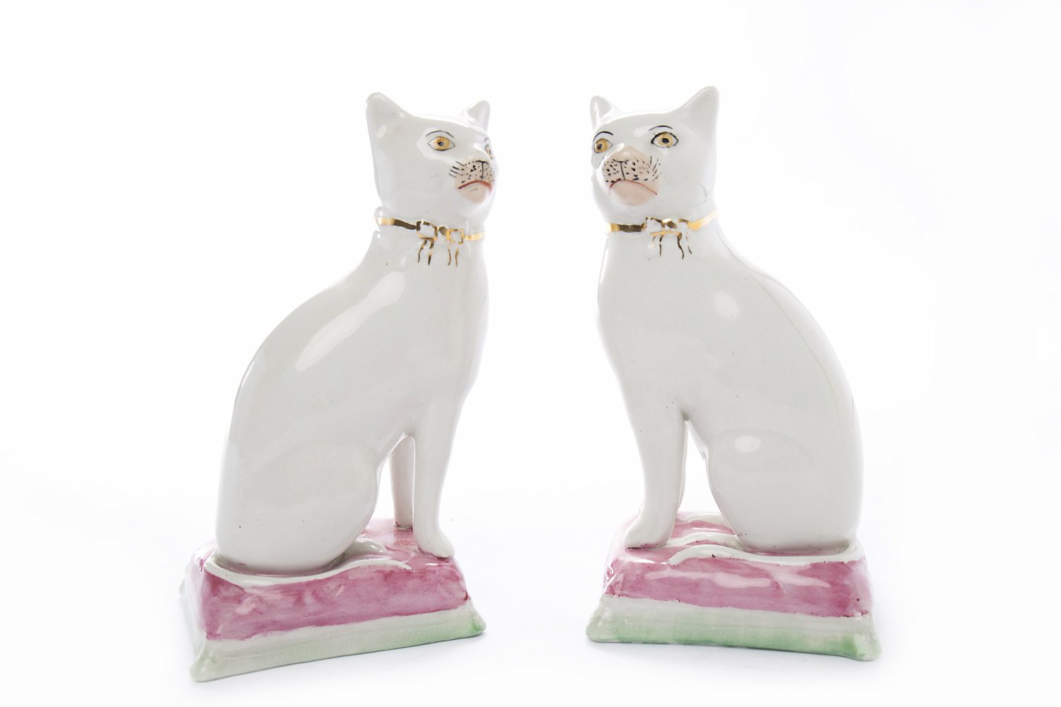 PAIR OF LATE 19TH CENTURY STAFFORDSHIRE WALLY CATS on pink and green cushions with gilt bows,