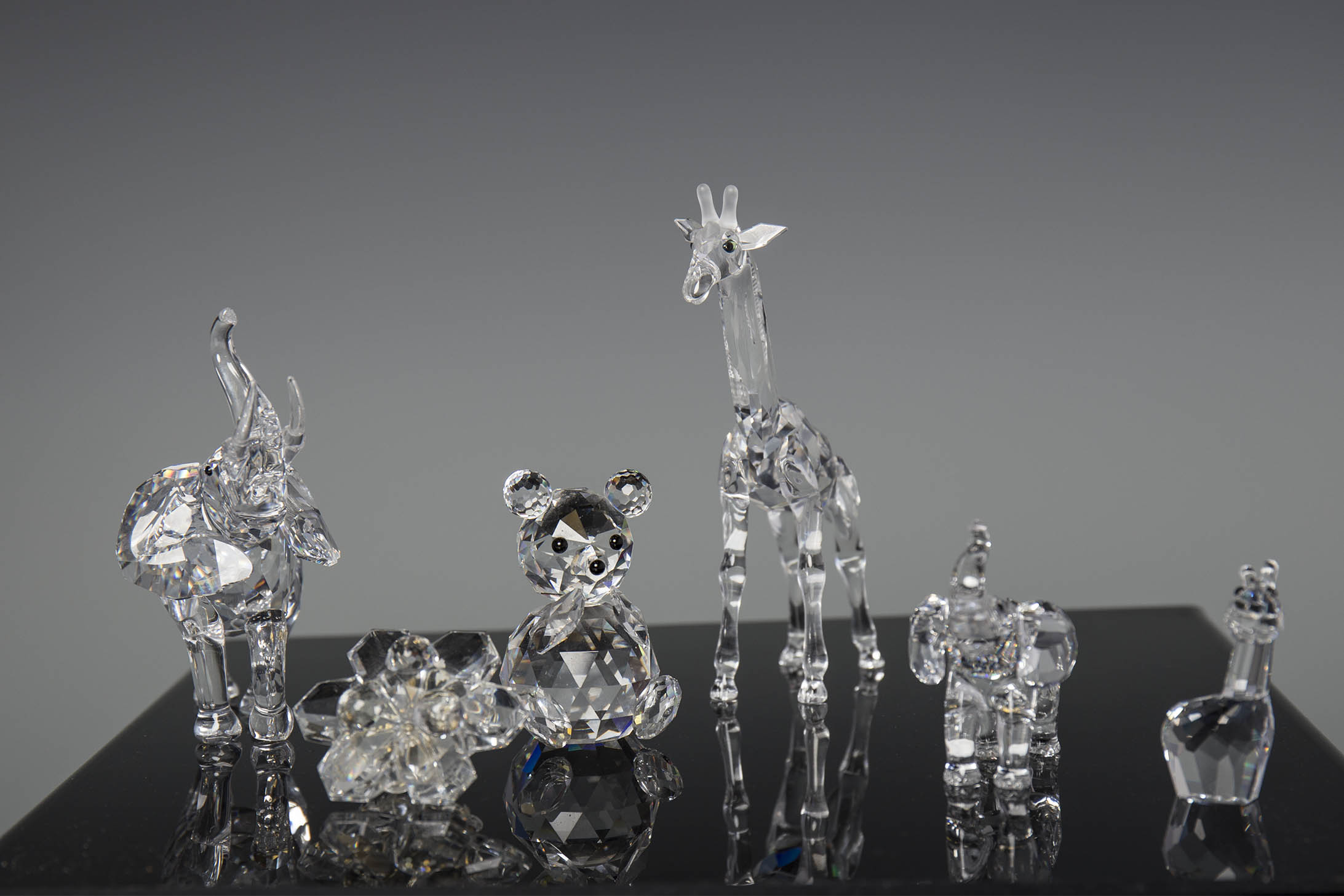 FIVE SWAROVSKI CRYSTAL ANIMAL FIGURES including two elephants, a giraffe,