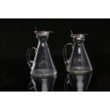 TWO SILVER MOUNTED GLASS WHISKY TOTS the tapering bodies on star cut bases,