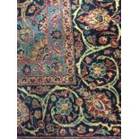 20TH CENTURY KASHAN BORDERED CARPET decorated with a large central floral medallion within a field