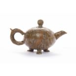 EARLY 20TH CENTURY CHINESE MINIATURE TEA POT in mottled browns and orange, on three feet,