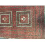 EARLY 20TH CENTURY PERSIAN RUG with three central motifs and fringed egde, on a red ground,