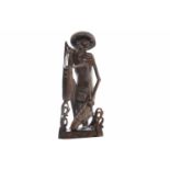 MID 20TH CENTURY THAI CARVED FIGURE OF A FISHERMAN modelled on one knee and carrying baskets,