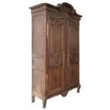 A LOUIS XV PROVINCIAL OAK ARMOIRE, with tongue and dart moulded three stage arched cornice,