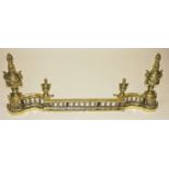 AN ORNATE HEAVY FRENCH CAST BRASS ADJUSTABLE FENDER, 
with two large urns, each with rams masks,
