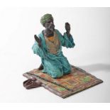 A COLD PAINTED BRONZE FIGURE, 
modelled as an Arab man on prayer rug, 5.5in (14cm).