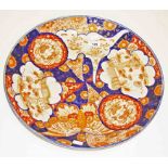 A CIRCULAR JAPANESE IMARI SAUCER DISH, 
19th century, decorated in various panels with flowers,