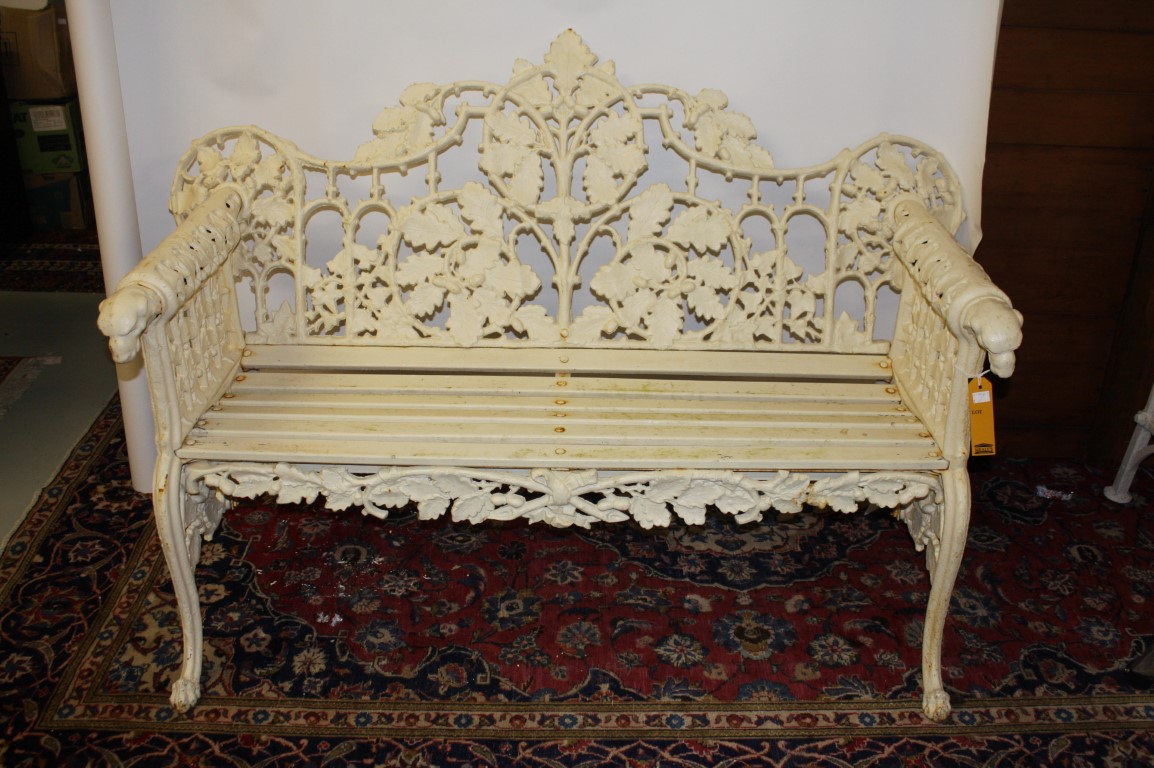 A HEAVY CAST IRON GARDEN BENCH, the back formed with scrolling oak leaves and acorns,