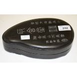 A HEAVY CHINESE INK STONE, of tear drop form, etched with calligraphy and in fitted hard wood case,