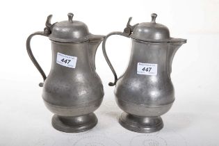 TWO LARGE PEAR SHAPED BALUSTER PEWTER JUGS, each with domed lid and mop finial,