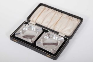 A PAIR OF CASED SILVER MACHINE TURNED ASH TRAYS, Sheffield 1950, each 3.5in (9cm), 147gr.