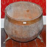 A LARGE COPPER MOUNTED POT BELLY WOODEN FUEL TUB, on three iron legs, 23" (58cm)d.
