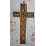 AN UNUSUAL PAINTED PINE CRUCIFORM RELICARY, the glazed front inset with semi precious stones,