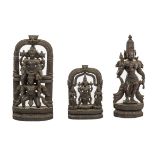 A CARVED INDIAN EBONY SHRINE, modelled with two deities under an arch,