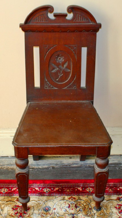 A PAIR OF EDWARDIAN MAHOGANY HALL CHAIRS, each with solid seat, raised on tapering legs.