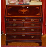 A GEORGE III MAHOGANY BUREAU, the slope front inlaid with a central urn and satinwood spandrels,