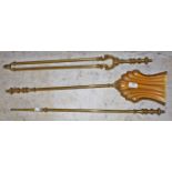 A SET OF THREE ATTRACTIVE BRASS FIRE IRONS, Edwardian, each with reeded stems and turned handles,