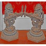 A PAIR OF HEAVY CAST IRON ANDIRONS, each in the form of a lion rampant holding a cross bar,