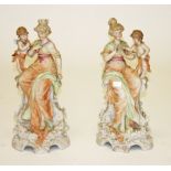A PAIR OF GERMAN BISQUE PORCELAIN GROUPS, each modelled as a classical woman with cherub,