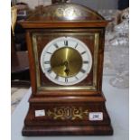 A BRASS INLAID MANTEL TIME PIECE, now with battery works and circular enamel dial,