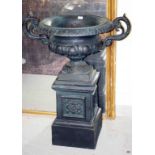 A PAIR OF TWO HANDLED CAST IRON GARDEN URNS, each with a foulded rim and two scroll handles,