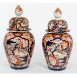A PAIR OF LARGE JAPANESE IMARI JARS AND COVERS, each with a reeded knop, on a domed cover,