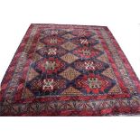 A HEAVY AFGHAN RUG, with three rows of diamond medallions, on a dark blue and fawn field,