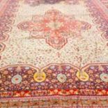 A LARGE PERSIAN STYLE CARPET, with centre red floral cruciform medallion, on an all-over pattern,