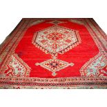 A TURKISH CARPET, with red and turquoise hexagonal centre medallion and two smaller medallions,