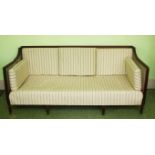 A MAHOGANY BERGERE SETTEE IN THE HEPPLEWHITE STYLE, with cane back and arm panels,