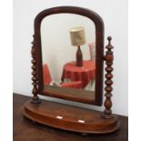 A VICTORIAN MAHOGANY DRESSING TABLE MIRROR, on bead turned supports, and an arched plate,