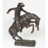 AFTER FREDERIC REMINGTON, a bronze equestrian group of a cowboy riding a bucking bronco,