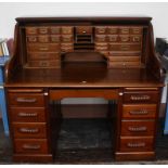 A ROLL TOP PEDESTAL WRITING DESK, 20th century, lacking its tambour,